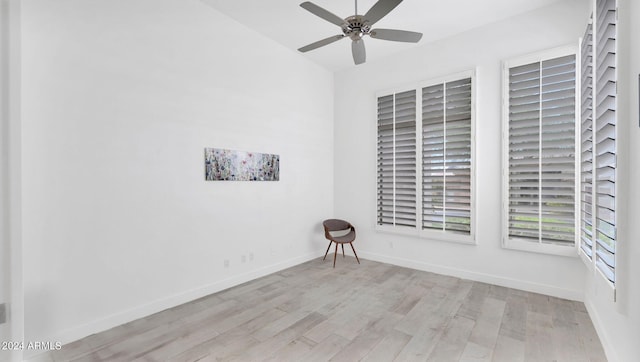 spare room with baseboards, a ceiling fan, and wood finished floors