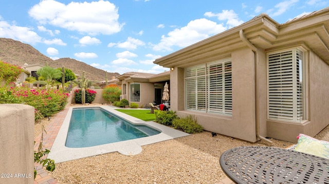 view of swimming pool with a patio area, a fenced in pool, and a mountain view