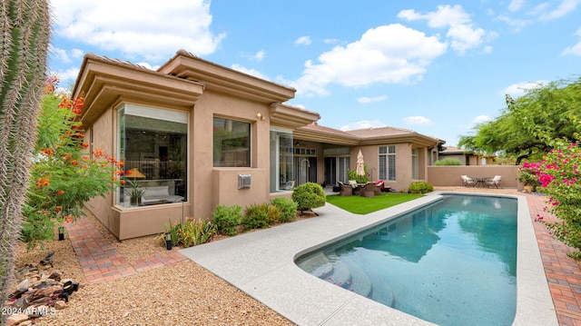 back of property featuring stucco siding, a patio, a fenced in pool, and fence