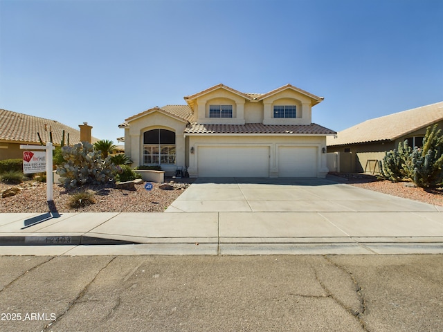 view of front of house featuring an attached garage, a tile roof, concrete driveway, and stucco siding