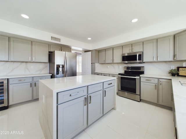 kitchen featuring stainless steel appliances, recessed lighting, tasteful backsplash, visible vents, and gray cabinetry