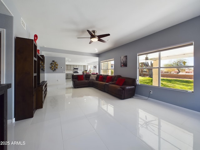 living area with light tile patterned floors, visible vents, and a ceiling fan