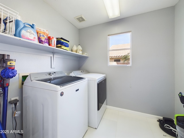 washroom featuring baseboards, laundry area, visible vents, and washer and dryer