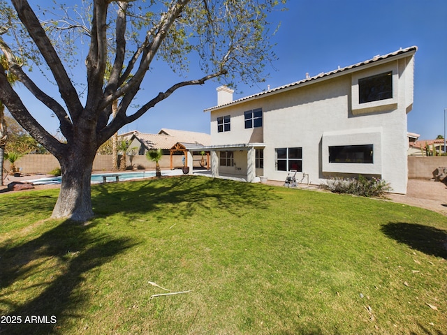 back of house with a fenced in pool, a fenced backyard, a yard, and a chimney