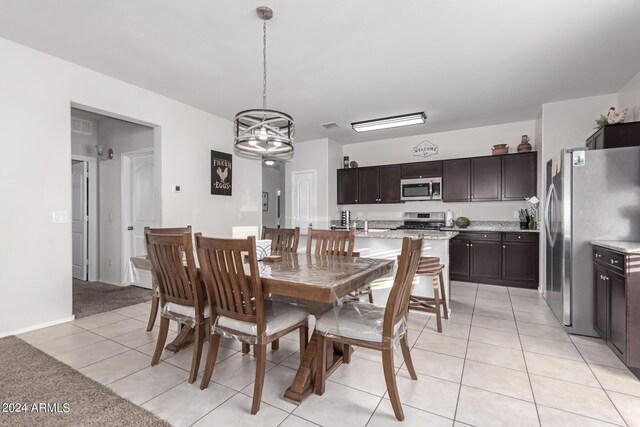 tiled dining area featuring an inviting chandelier