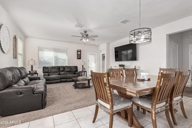 tiled dining area with ceiling fan with notable chandelier