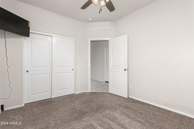 unfurnished bedroom featuring light carpet, a closet, and ceiling fan