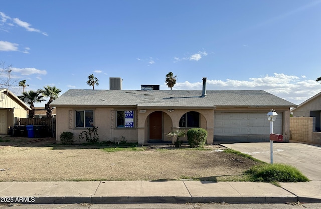 view of front facade featuring a shingled roof, an attached garage, concrete driveway, fence, and stucco siding
