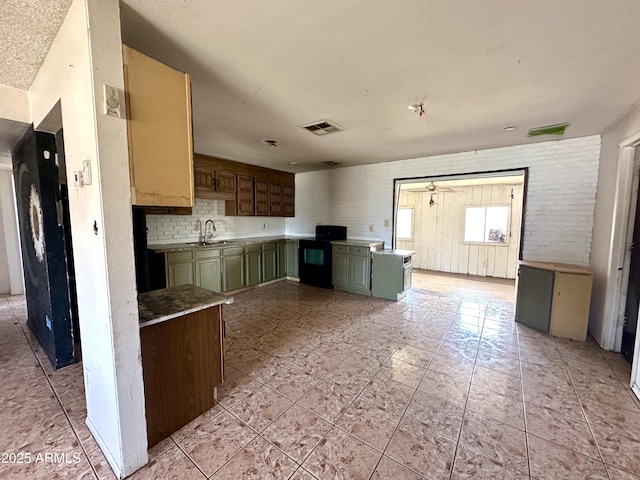 kitchen with visible vents, ceiling fan, green cabinetry, black range with electric stovetop, and a sink