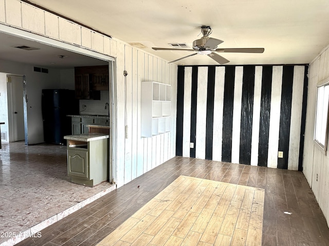 interior space featuring wood finished floors, ceiling fan, and visible vents