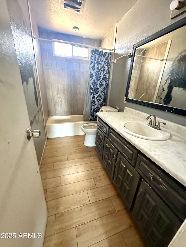bathroom featuring a textured ceiling, vanity, toilet, curtained shower, and wood tiled floor