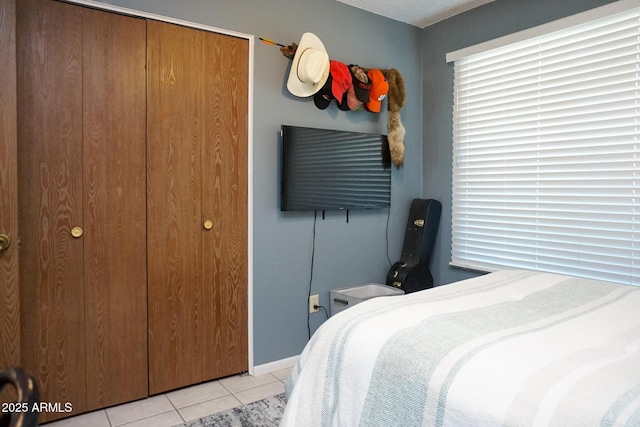 tiled bedroom featuring a closet and a textured ceiling