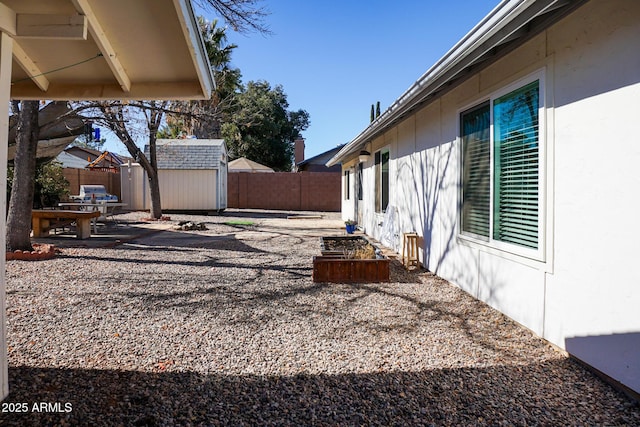 view of yard featuring a storage shed and a patio