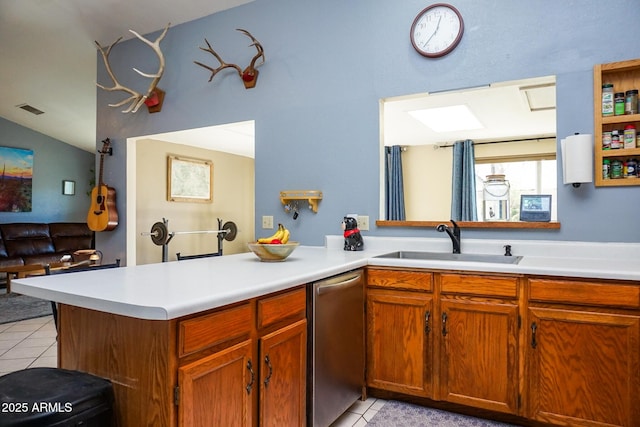 kitchen with kitchen peninsula, dishwasher, sink, and light tile patterned floors