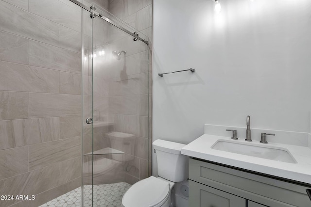 bathroom with vanity, a shower with shower door, and toilet