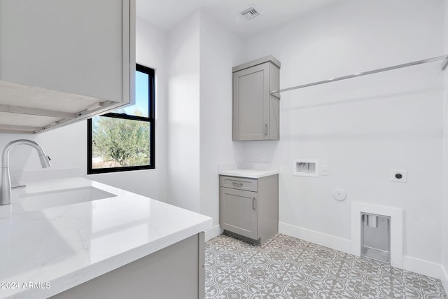 laundry room featuring gas dryer hookup, sink, electric dryer hookup, cabinets, and washer hookup