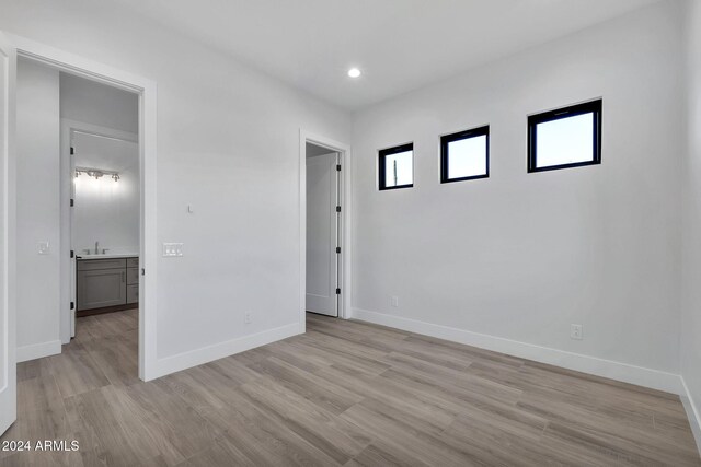 unfurnished room with sink and light wood-type flooring