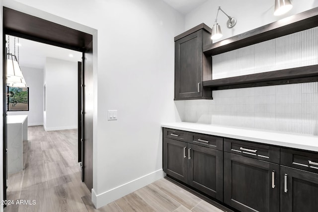 bar featuring light wood-type flooring and decorative backsplash