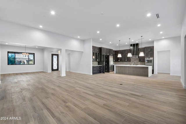 unfurnished living room featuring sink and light wood-type flooring