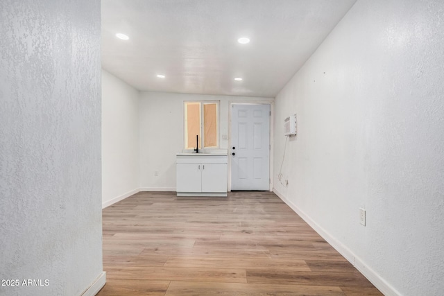 3913 W Sherman St, Phoenix, AZ 85009 - spare room with light wood-style flooring, recessed lighting, a textured wall, baseboards, and a sink