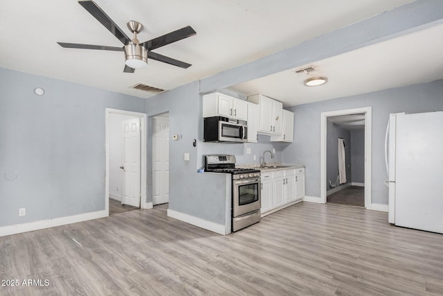 3913 W Sherman St, Phoenix, AZ 85009 - kitchen featuring appliances with stainless steel finishes, a sink, ceiling fan, baseboards, and light wood-style floors