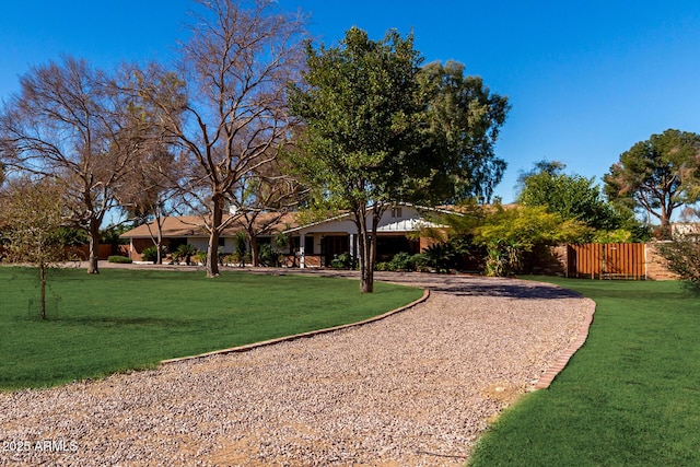 view of yard with fence and driveway