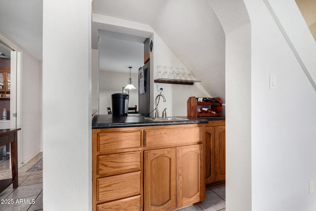 bar featuring sink, decorative light fixtures, and light tile patterned flooring