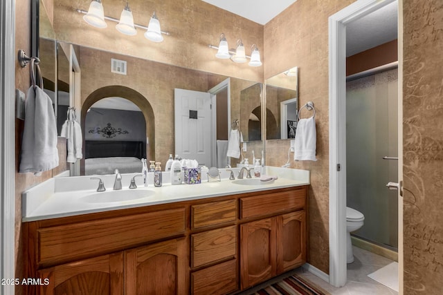 bathroom featuring vanity, toilet, an enclosed shower, and tile patterned flooring