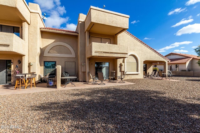 back of property with a balcony and a patio area