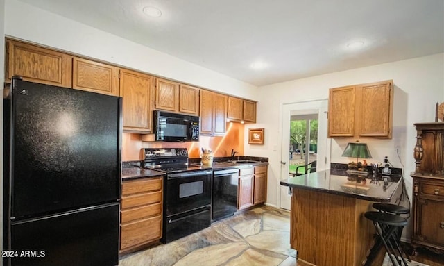 kitchen with light wood-type flooring, black appliances, and sink