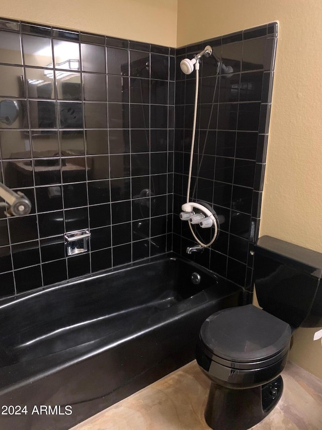 bathroom featuring toilet and tiled shower / bath combo