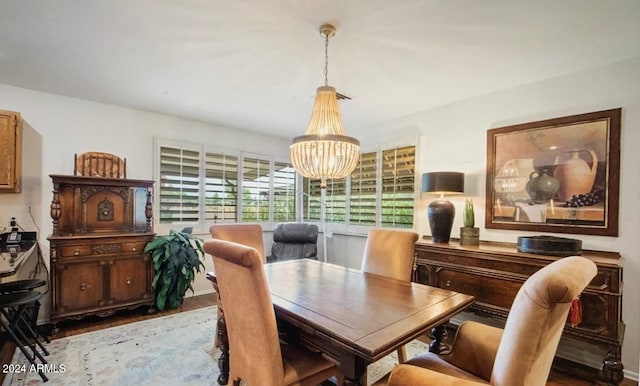 dining area with light hardwood / wood-style floors and a notable chandelier