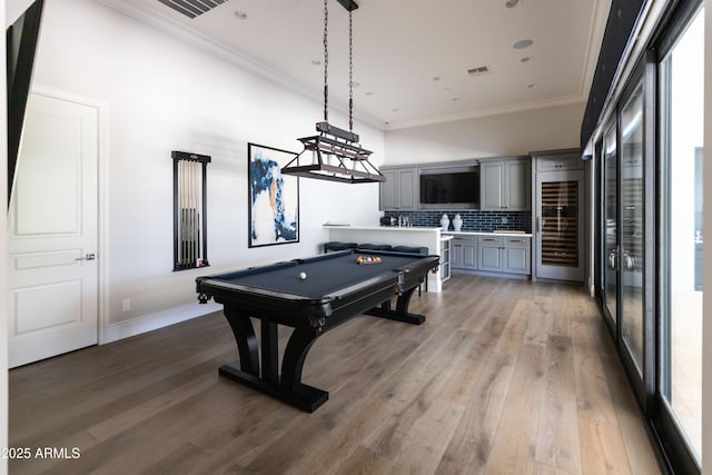 game room with light wood finished floors, visible vents, pool table, and ornamental molding