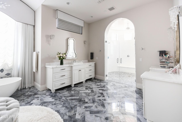 bathroom featuring visible vents, a shower stall, a soaking tub, marble finish floor, and vanity