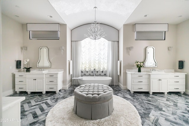 bathroom featuring two vanities, baseboards, and marble finish floor