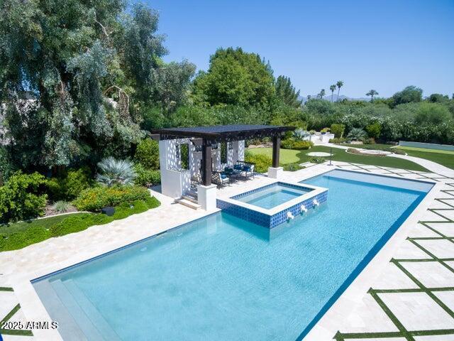 view of swimming pool featuring a patio and a pool with connected hot tub