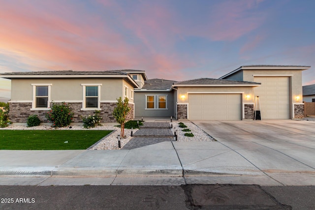 18139 W Oregon Ct, Litchfield Park, AZ 85340 - prairie-style home with stucco siding, stone siding, an attached garage, and concrete driveway