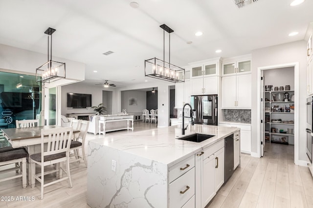 18139 W Oregon Ct, Litchfield Park, AZ 85340 - kitchen with a sink, stainless steel refrigerator with ice dispenser, white cabinetry, glass insert cabinets, and light stone counters