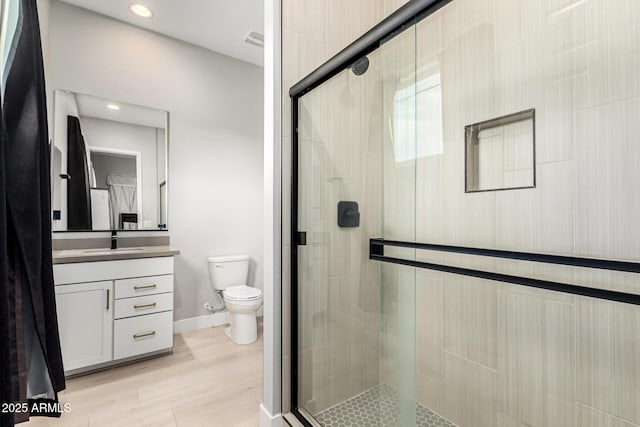 18139 W Oregon Ct, Litchfield Park, AZ 85340 - full bath with vanity, a shower stall, toilet, wood finished floors, and recessed lighting