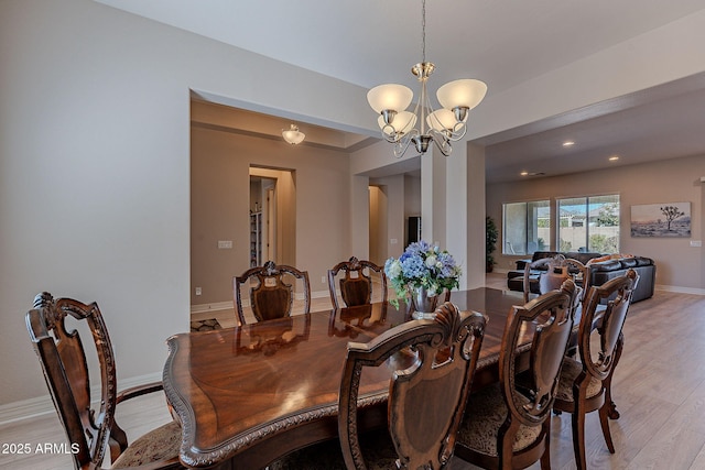 dining room featuring a notable chandelier and light wood-type flooring