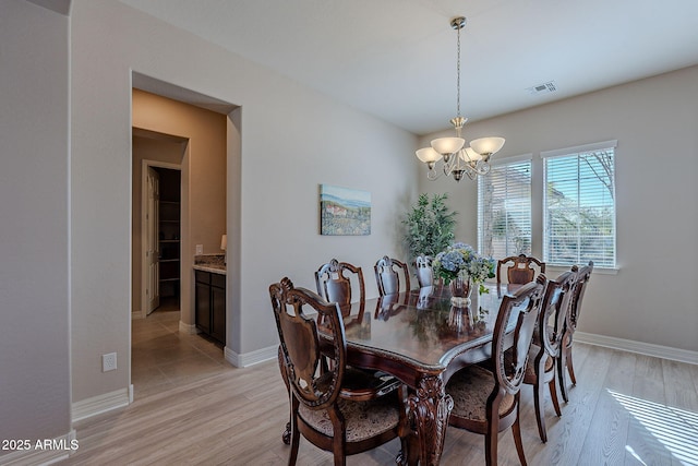 dining area featuring a chandelier and light hardwood / wood-style flooring