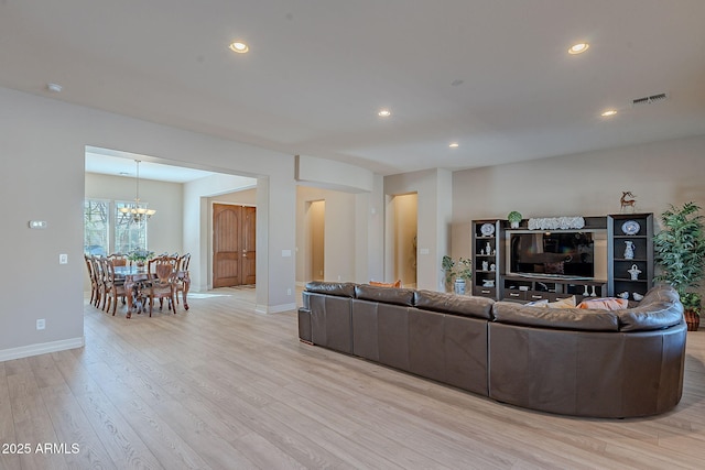 living room with a chandelier and light wood-type flooring