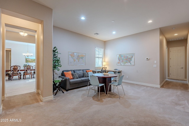 carpeted dining room featuring an inviting chandelier