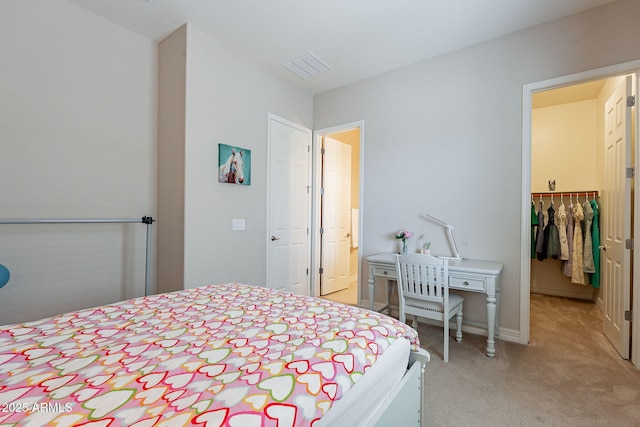 bedroom with a closet, a spacious closet, and light carpet