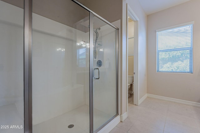 bathroom with plenty of natural light, an enclosed shower, tile patterned floors, and toilet