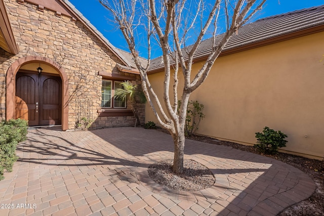 view of exterior entry with a patio