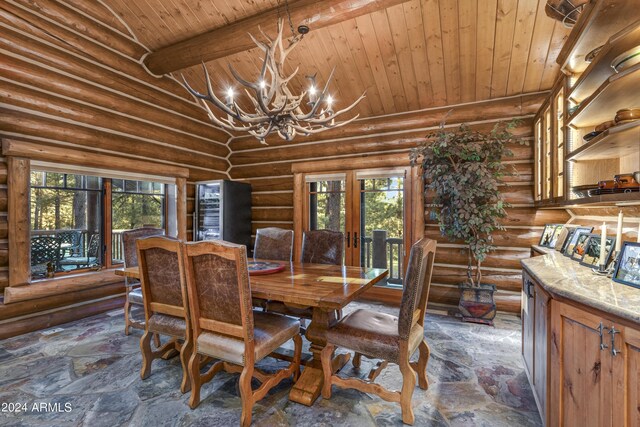 dining room with plenty of natural light, a notable chandelier, and rustic walls