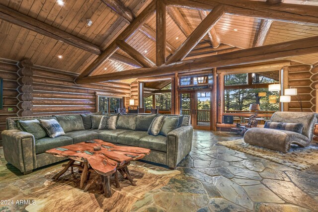 living room with rustic walls, high vaulted ceiling, beam ceiling, and wooden ceiling