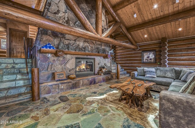 unfurnished living room with log walls, wood ceiling, beamed ceiling, a stone fireplace, and high vaulted ceiling