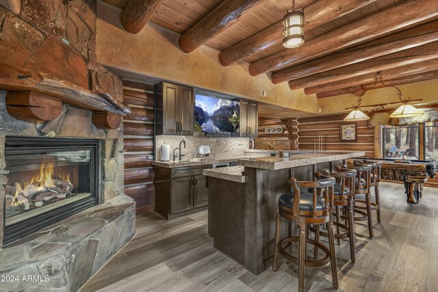 kitchen featuring light stone countertops, decorative light fixtures, a fireplace, billiards, and hardwood / wood-style floors